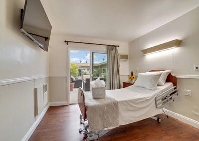 Bedroom with single bed and TV and patio door